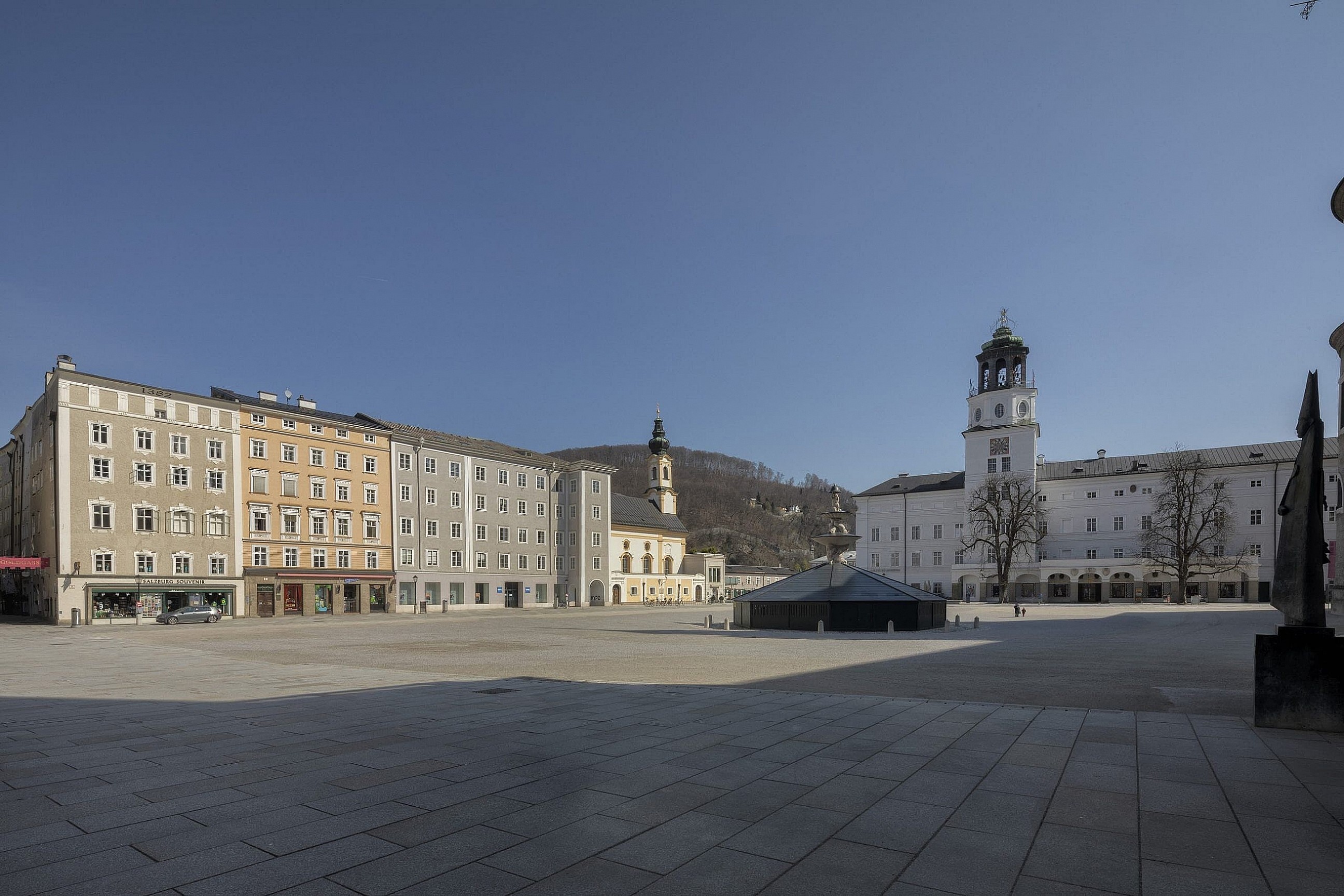 A quiet and empty Residenzplatz, Salzburg during corona virus lockdown. Showing the fountain and surrounding shops and museums all shut down