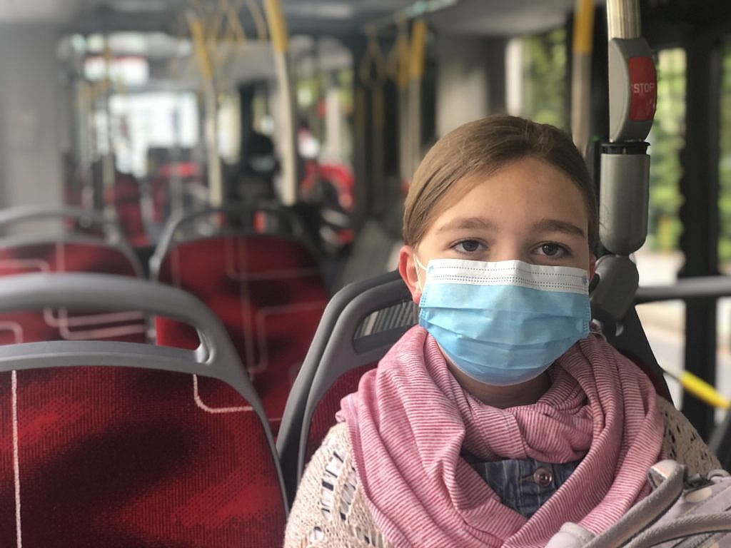 Photograph of Sienna on the bus wearing a face mask