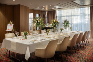 Dining space with white linen tables and floral event styling at Sheraton Grand Salzburg