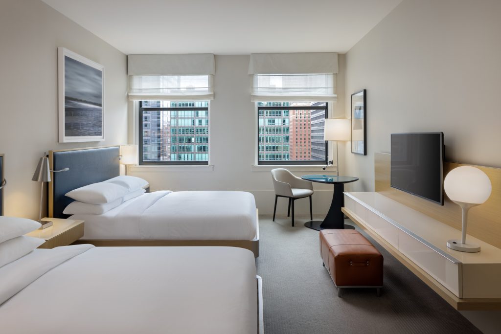 Double queen guest room with classic windows and sleek workspace at Hyatt Centric.