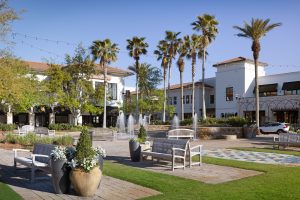 Outdoor plaza at Grand Boulevard with fountain, palm trees, and seating.