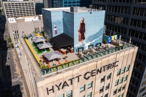 Elevated rooftop view of Hyatt Centric with seating area and large mural.