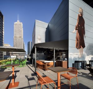 Daytime view of Aire rooftop bar with modern seating and Chicago skyline.