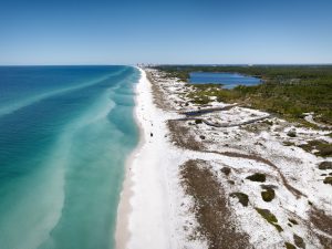 Aerial view of untouched white sand beach and dune landscape near Topsail Hill Preserve.