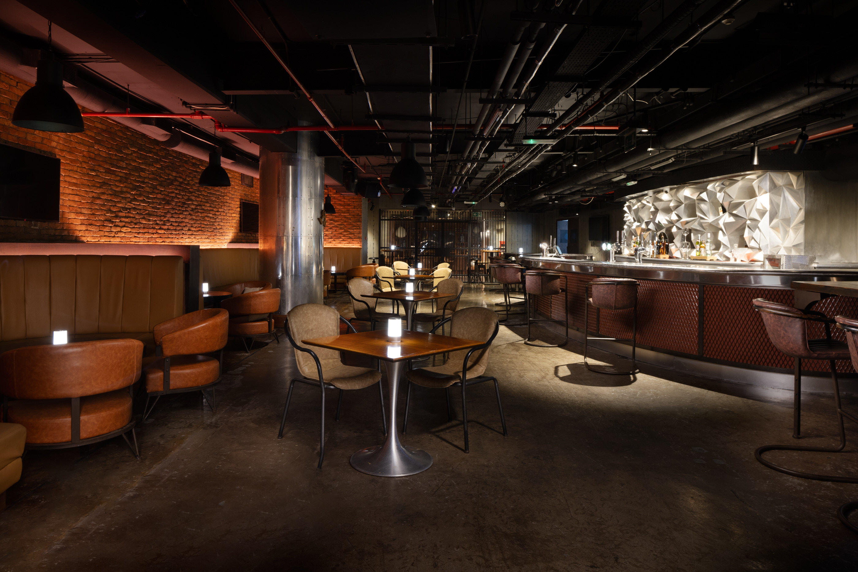 Evening bar at Sheraton Muscat with moody lighting and modern seating.'