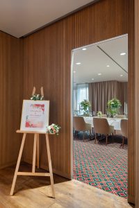 Event signage with elegant meeting room reflection at Sheraton Grand Salzburg