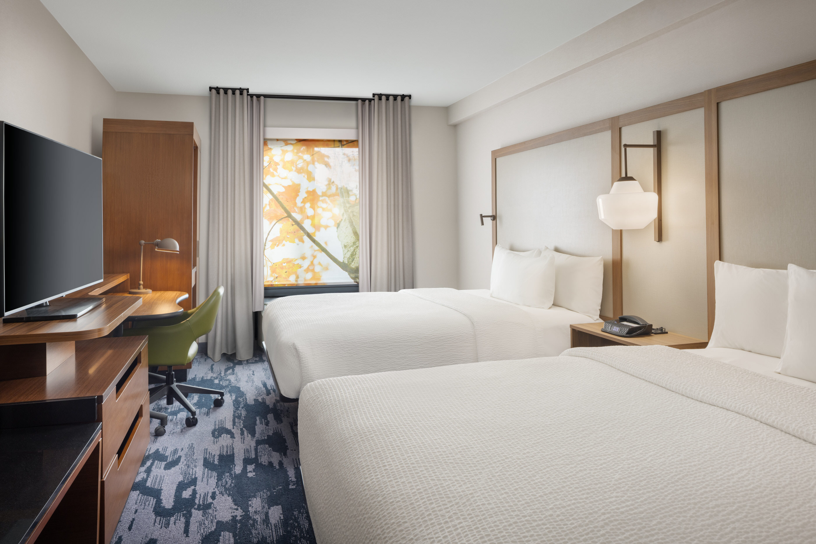 Twin beds with window view and neutral tones in a renovated room at Fairfield Inn Mission Viejo