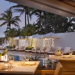 Open-air dining with cabanas in the background at MB Hotel