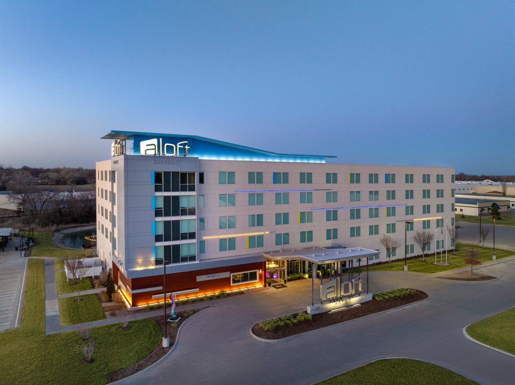 Aloft Wichita exterior at dusk with bold signage and modern façade.
