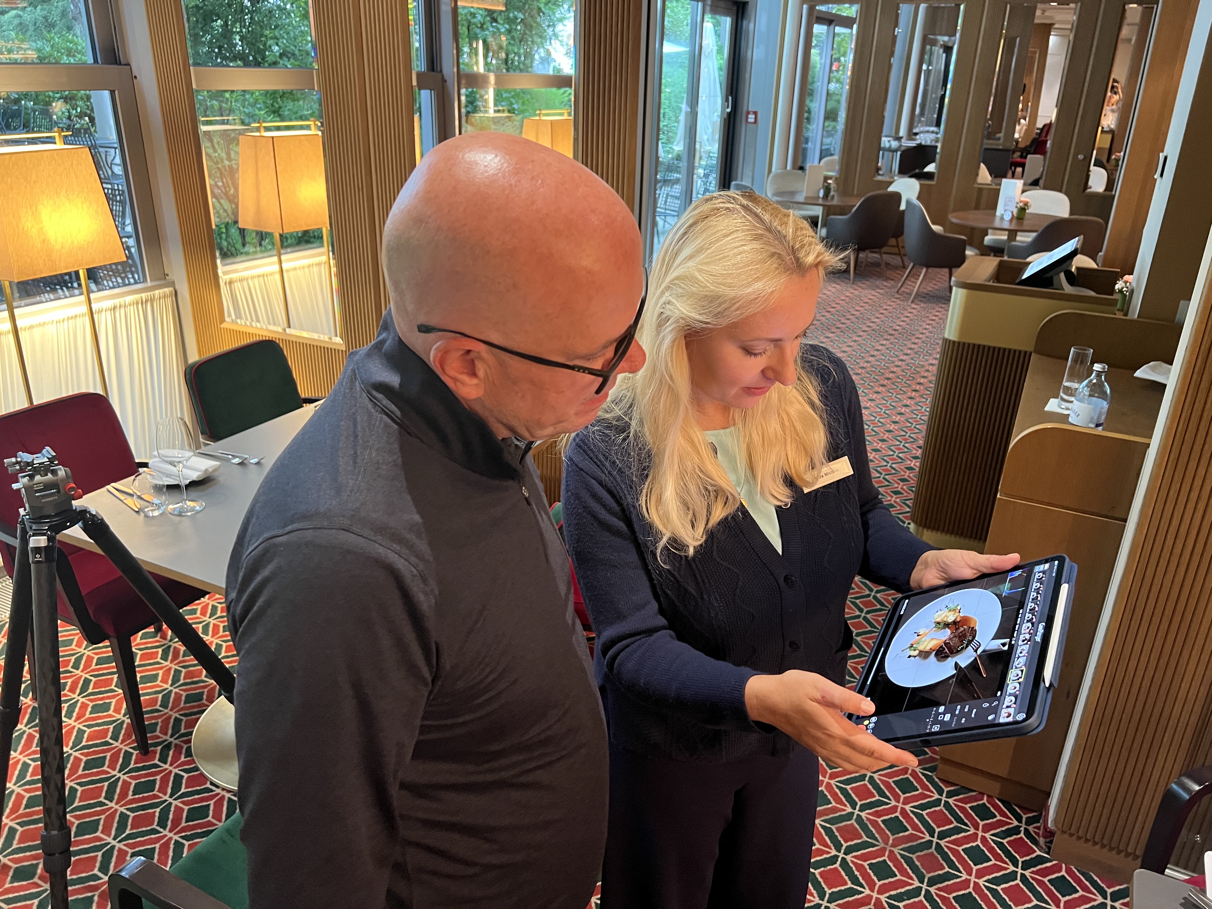 Hotel photographer Steven Graffham reviewing freshly captured images on-location with Vera Mashina, Director of Marketing at Sheraton Grand Salzburg, during a pre-shoot collaboration to ensure brand-level photo quality.