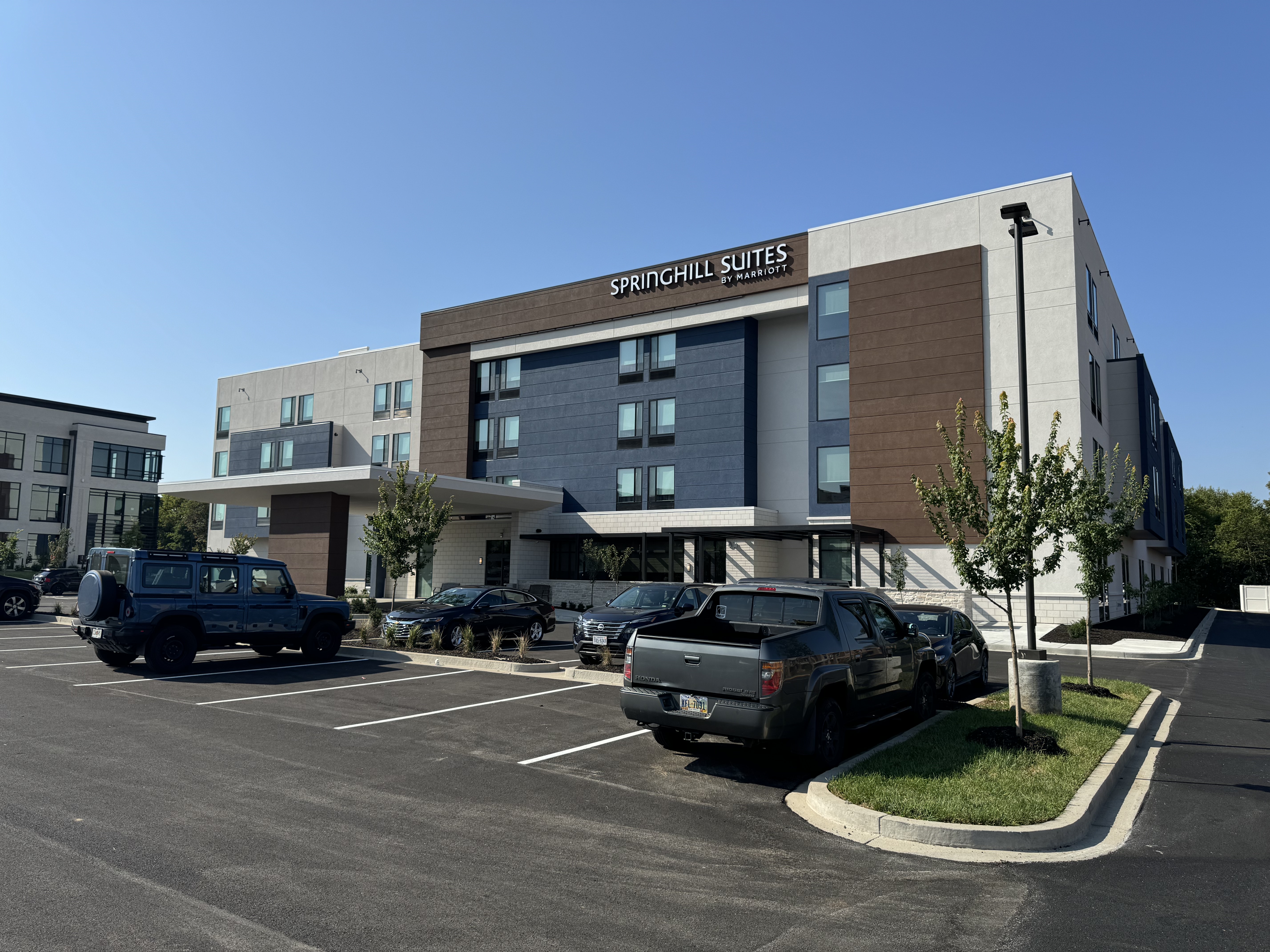Hotel exterior with a full car park and multiple guest vehicles obstructing the view, used as a before image to show why car park management is critical for hotel photography.