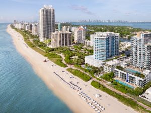 Aerial view of MB Hotel Miami Beach between taller oceanfront buildings on Collins Avenue