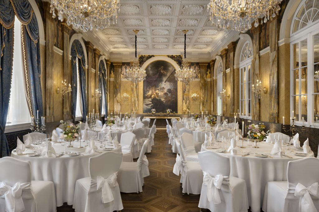 Grand chandelier-lit banquet room prepared with formal dining tables at Hotel Imperial Vienna