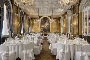 Grand chandelier-lit banquet room prepared with formal dining tables at Hotel Imperial Vienna